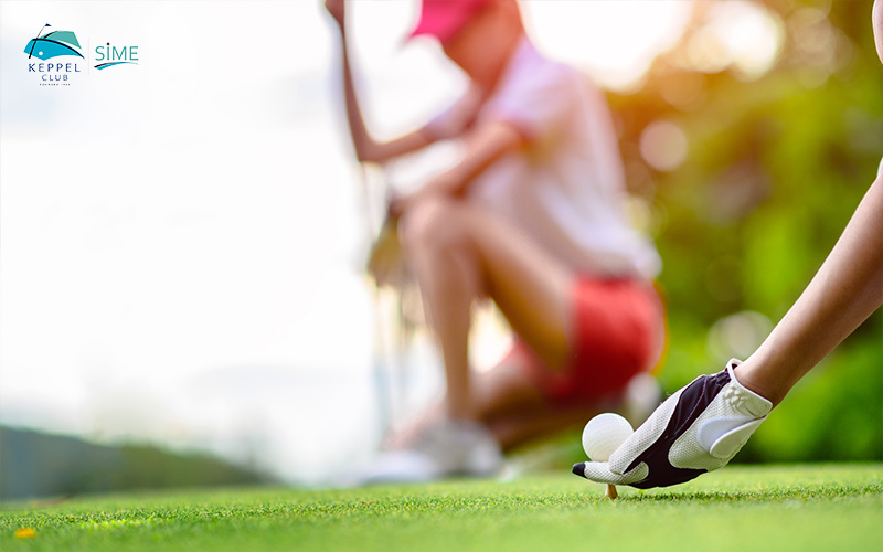 Young Woman Golf Player Holding Golf Ball Laying On Wooden