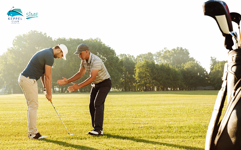 young golfer practicing a swing under the guidance of his instructor